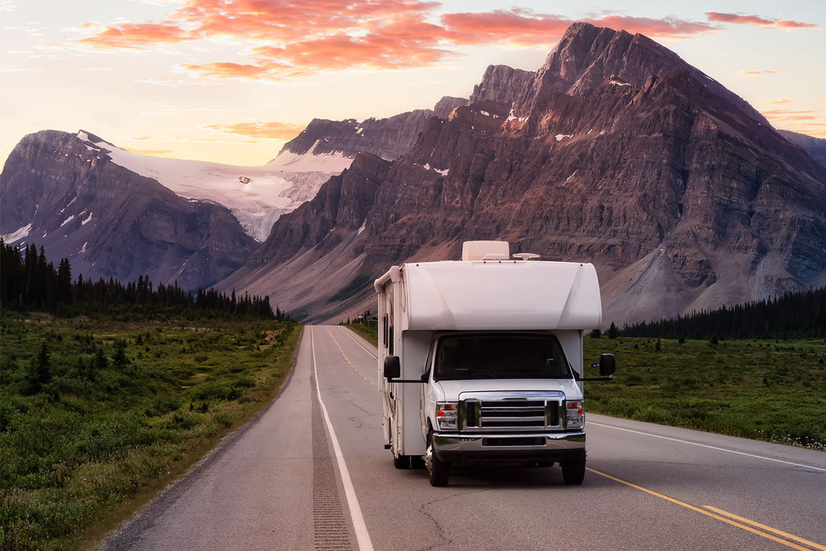 RV driving on a road between mountains